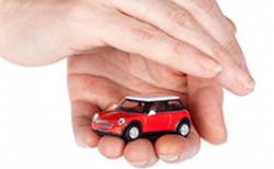 Main protégeant une voiture miniature
