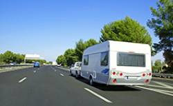 Voiture tractant une caravane sur une voie d'autoroute