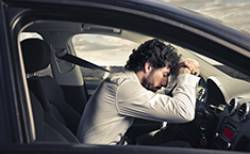 Homme couché sur son volant